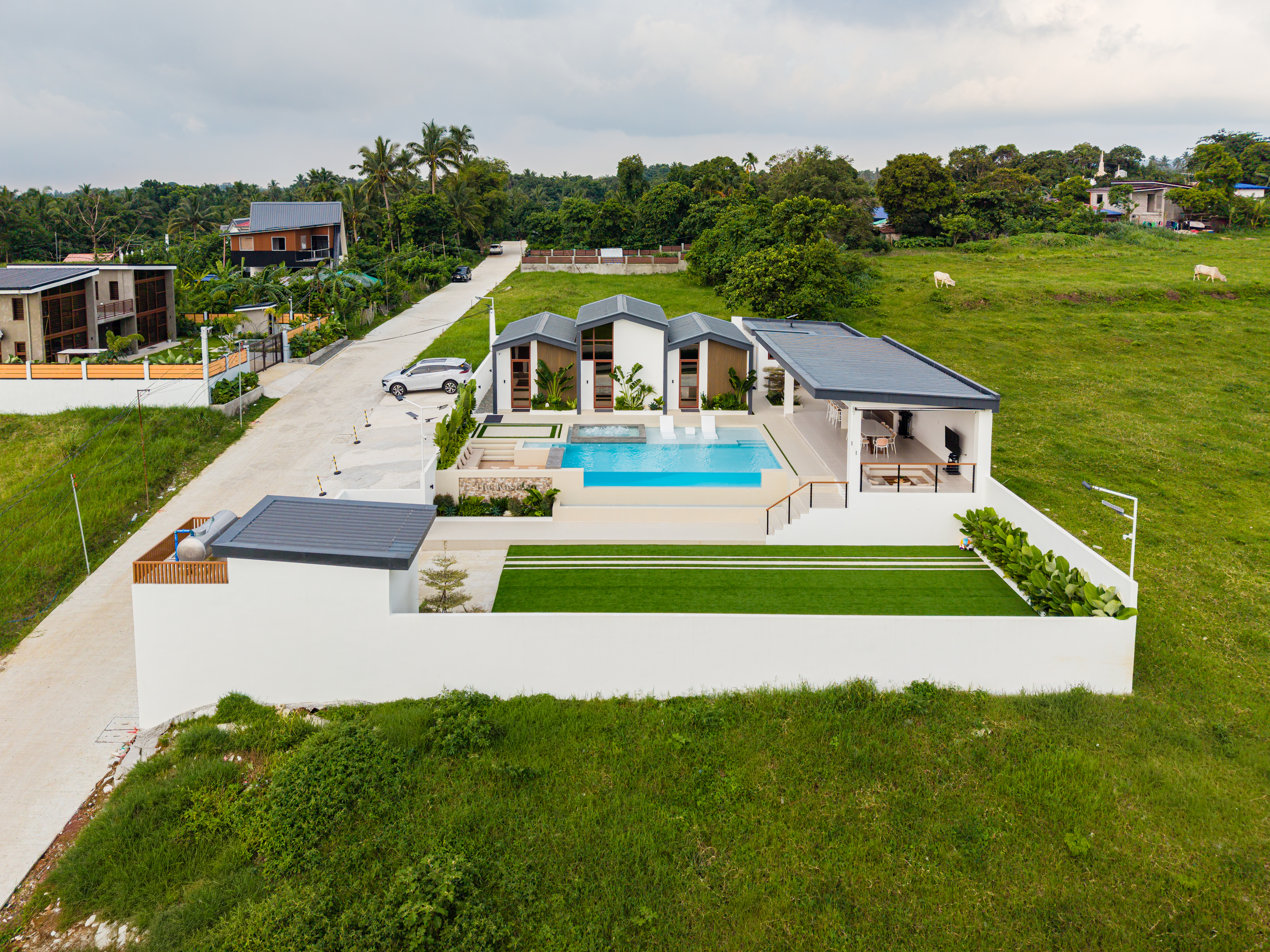 Drone view of The Kasiden Private Resort featuring three villas, infinity pool, gazebo, and open grounds in Alfonso, Cavite.