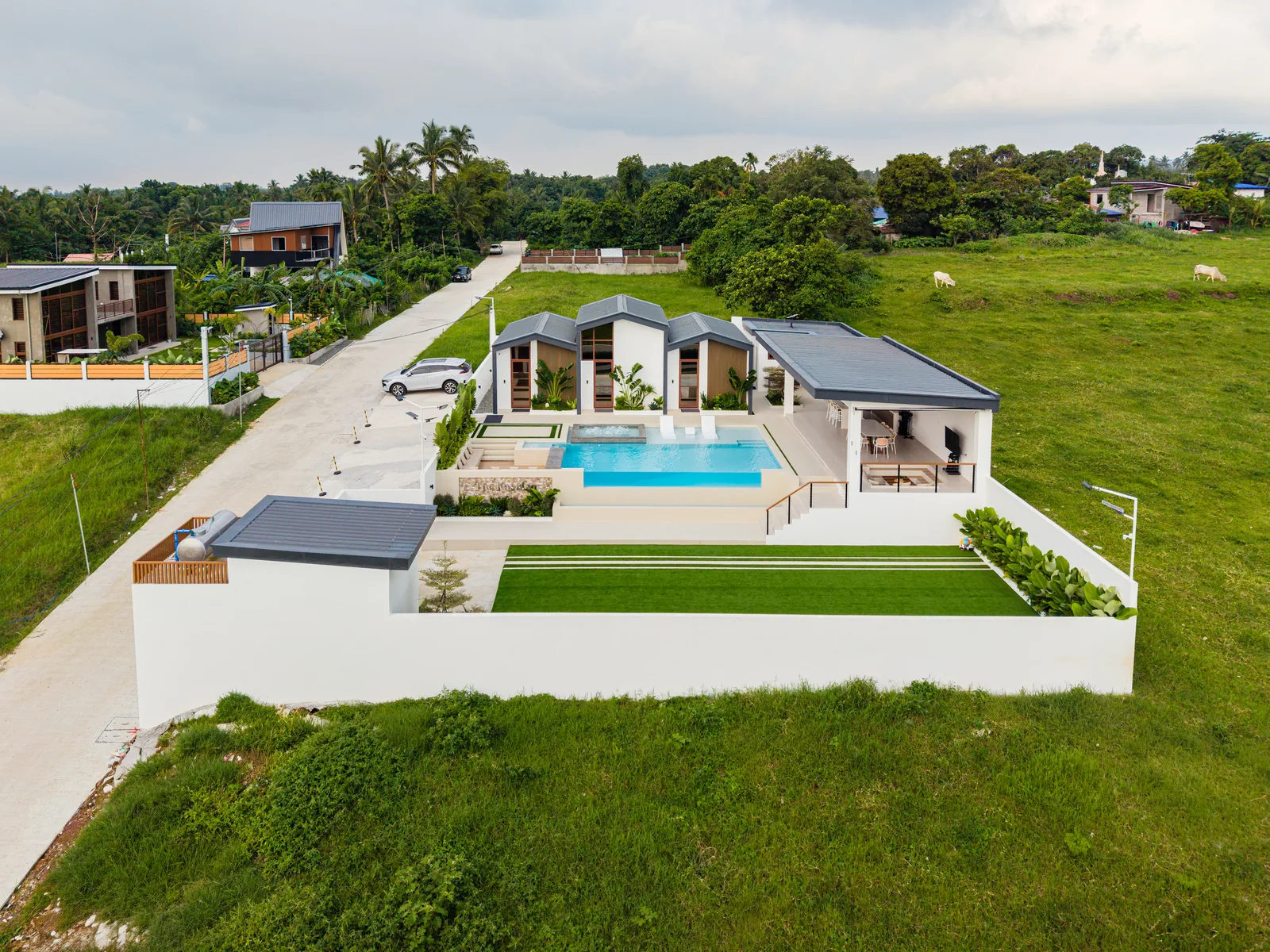 Drone view of The Kasiden Private Resort featuring three villas, infinity pool, gazebo, and open grounds in Alfonso, Cavite.