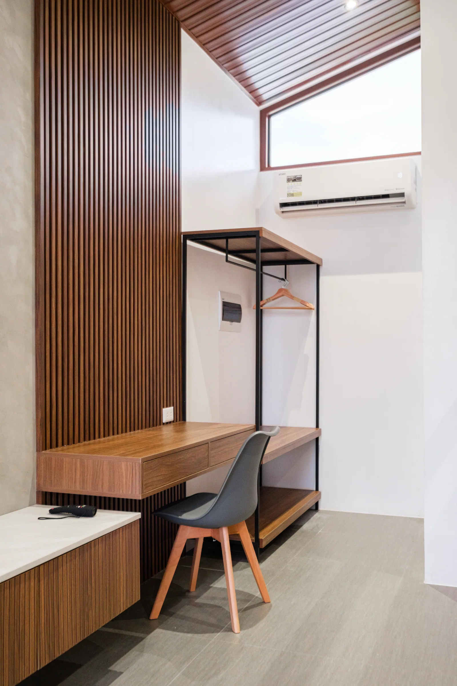 Modern villa workspace with desk, luggage storage, clothing rack, and air conditioning at The Kasiden Private Resort.