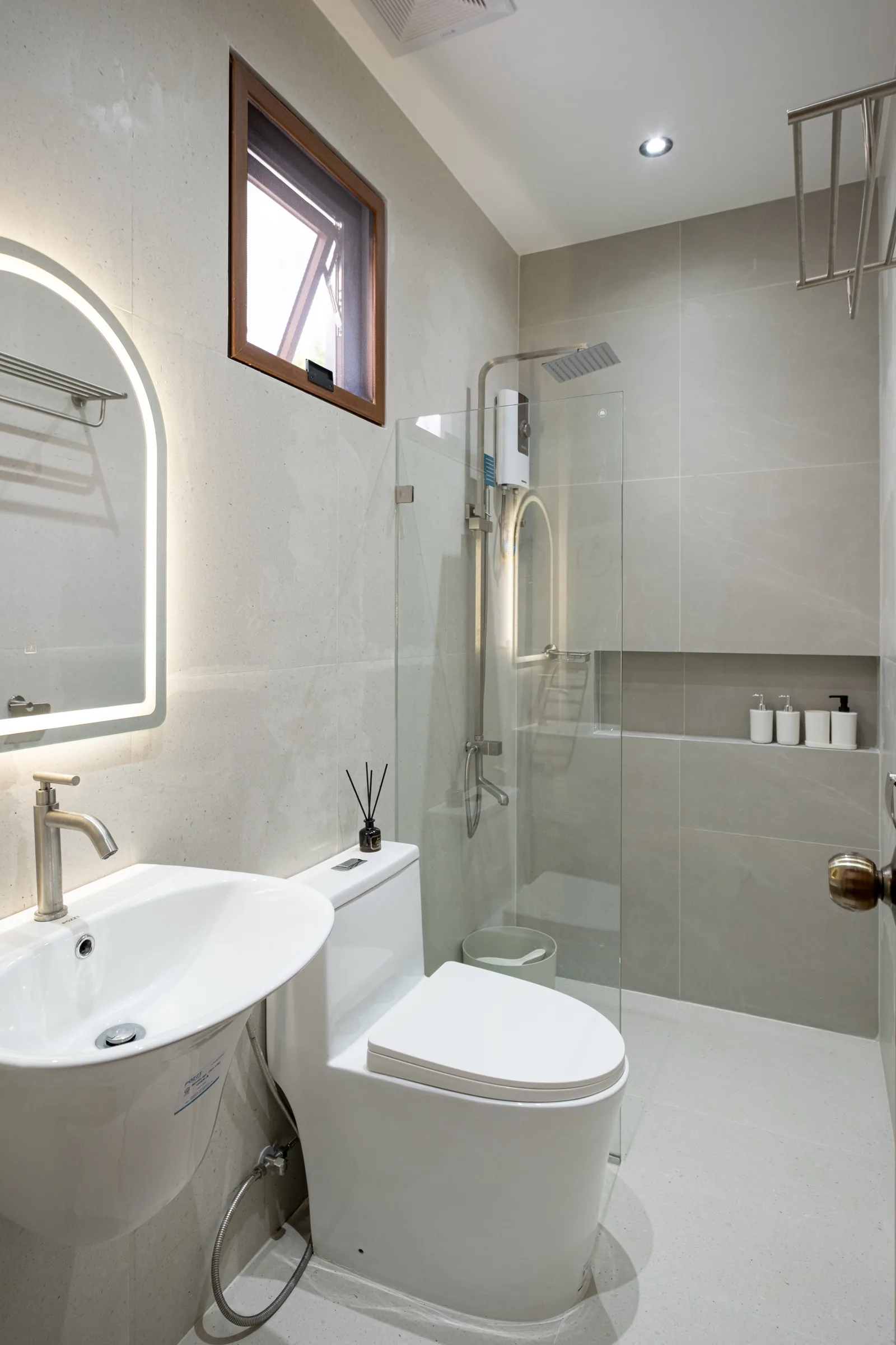 Modern ensuite bathroom featuring a rain shower, glass enclosure, illuminated mirror, and contemporary fixtures at The Kasiden Private Resort in Alfonso, Cavite.