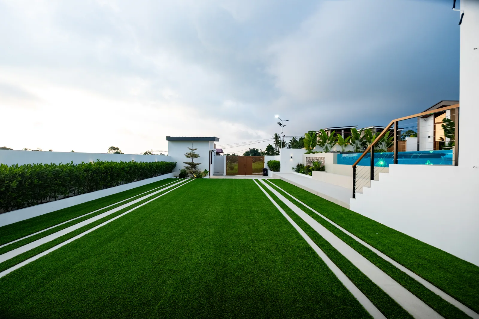 Wide event lawn with views of the pool, villas, and gathering spaces at The Kasiden.