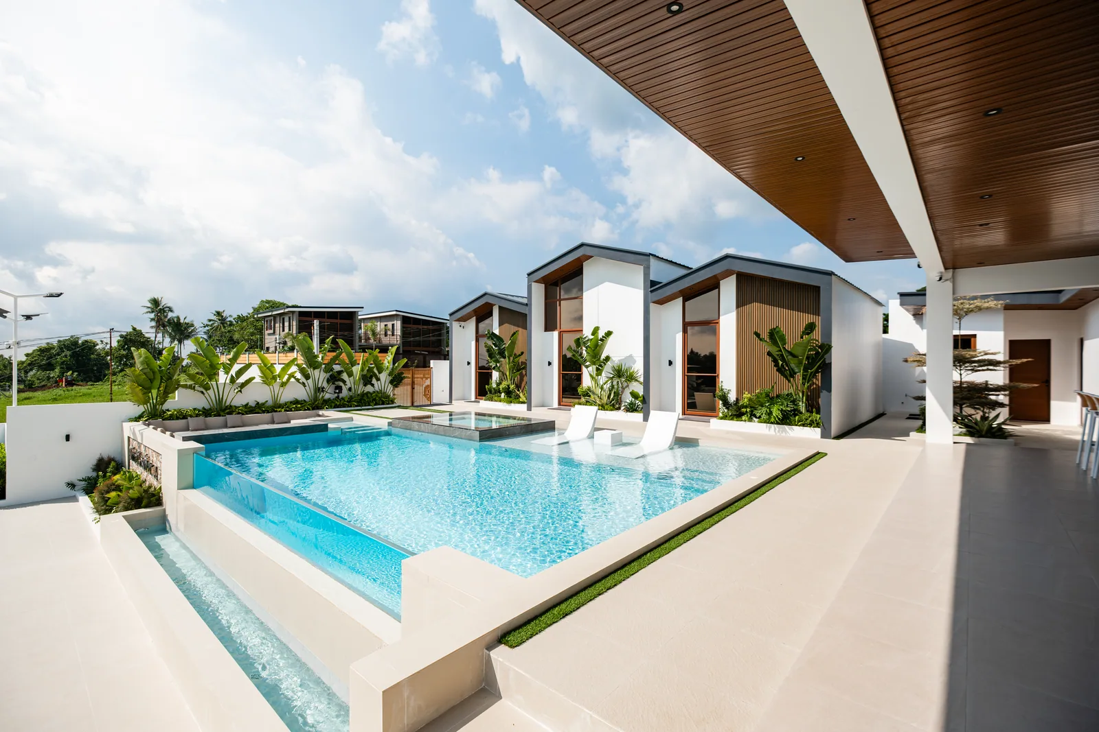 Wide view of the infinity pool, jacuzzi, villas, and gazebo.