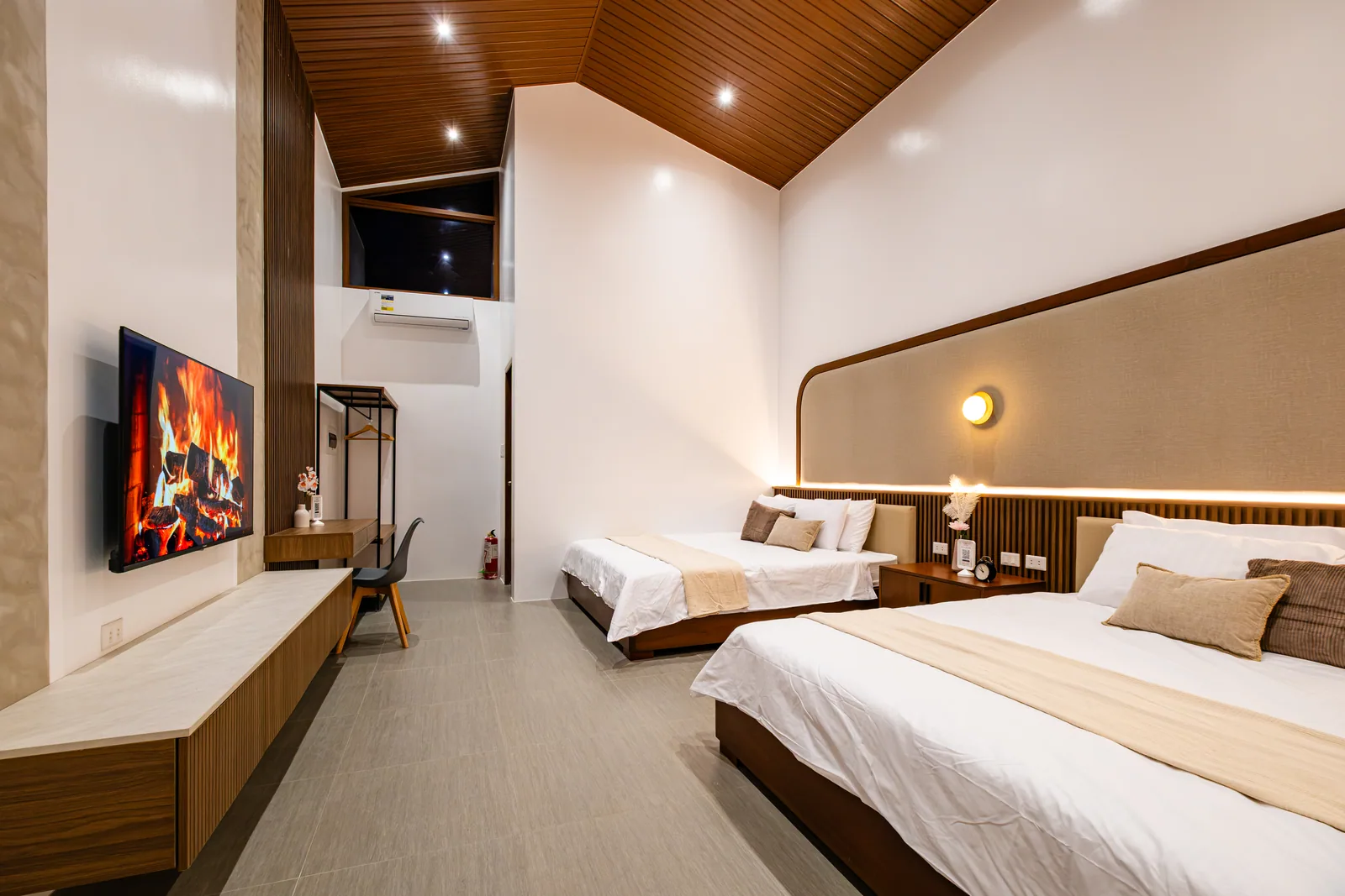 Modern family suite with two king-size beds, smart TV, workspace, and contemporary furnishings at The Kasiden Private Resort.