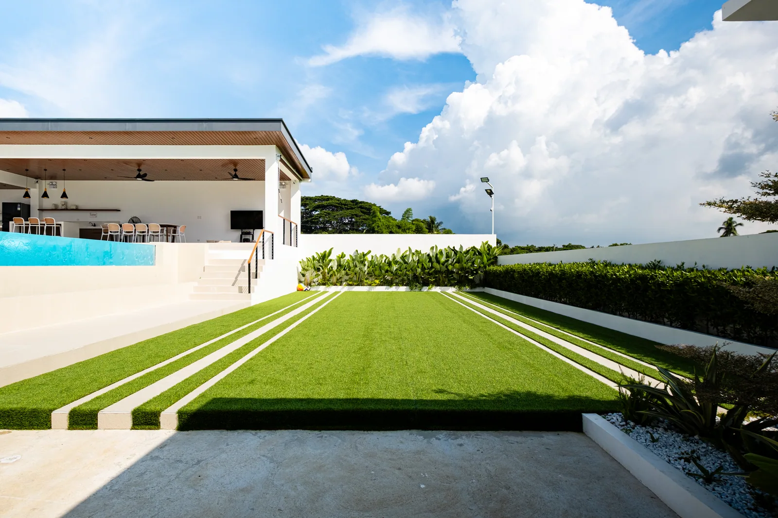 Large artificial grass lawn for family activities, outdoor games, and events at The Kasiden Private Resort.