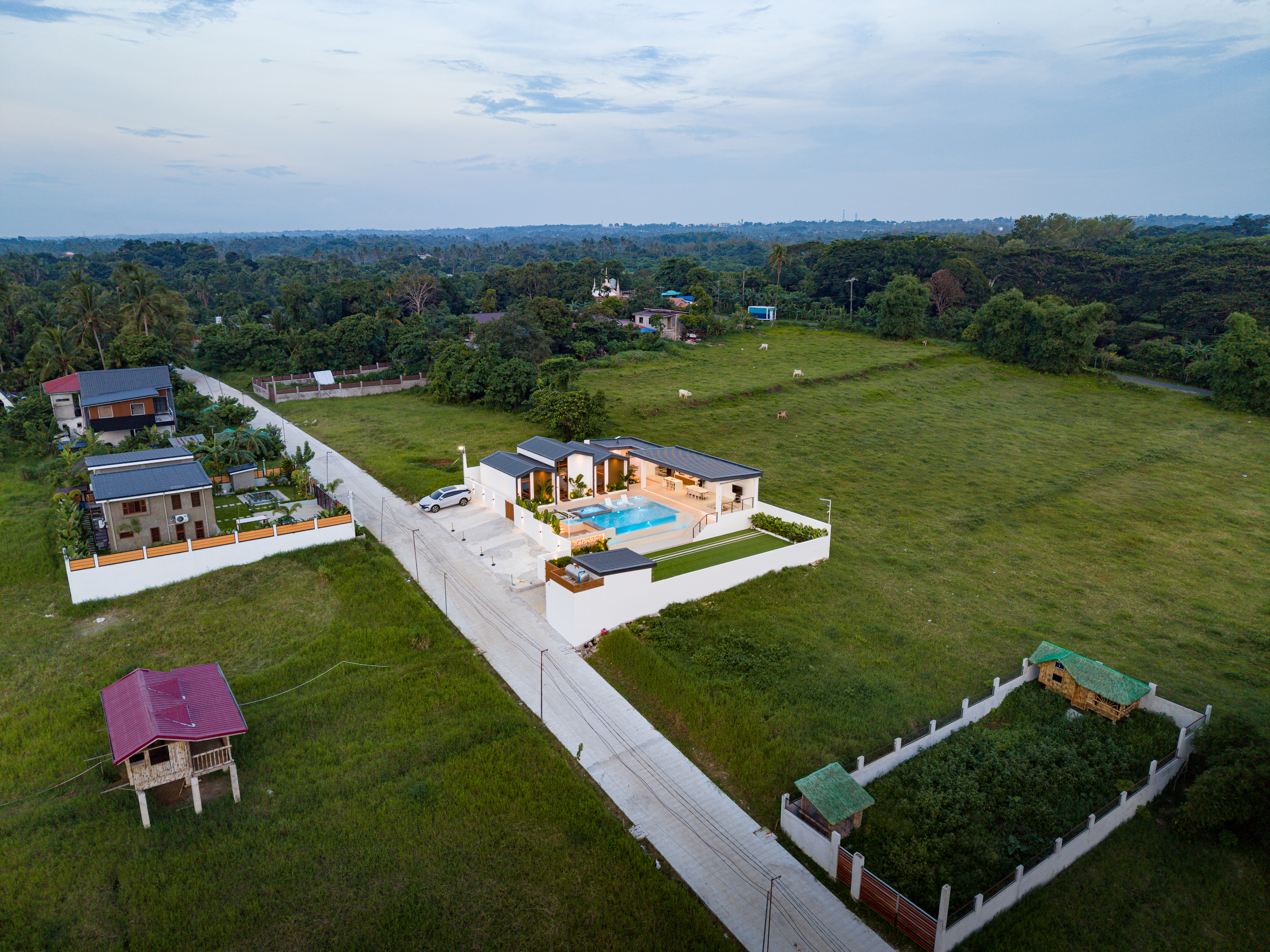 High aerial drone view of The Kasiden Private Resort surrounded by countryside landscapes and open green spaces.