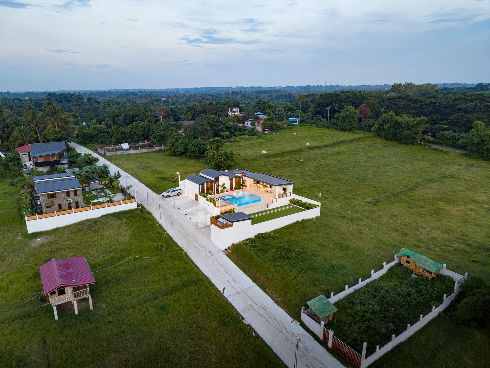 High aerial drone view of The Kasiden Private Resort surrounded by countryside landscapes and open green spaces.