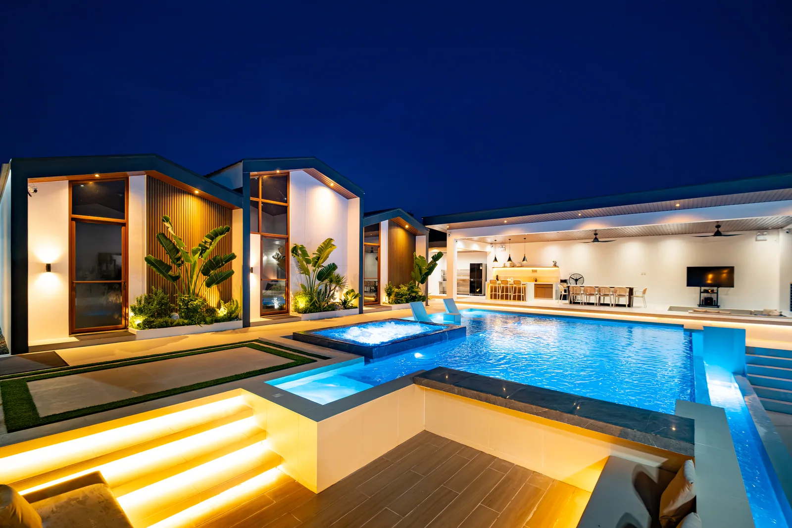 Illuminated poolside sunken lounge beside the infinity pool.