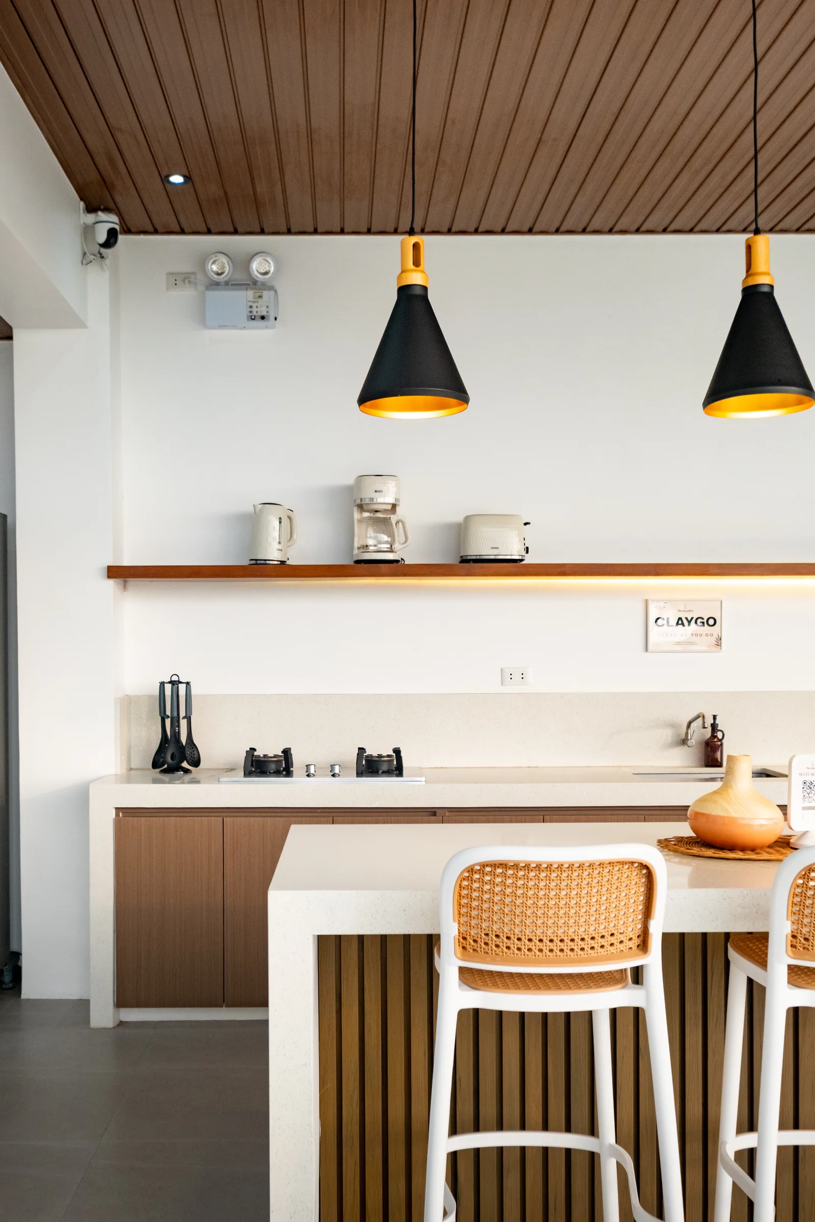 Fully equipped open-air kitchen with island counter, bar seating, coffee maker, kettle, toaster, and cooking facilities at The Kasiden Private Resort.
